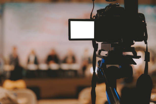 professional video production camera recording live event on stage. television social media broadcasting seminar conference.
